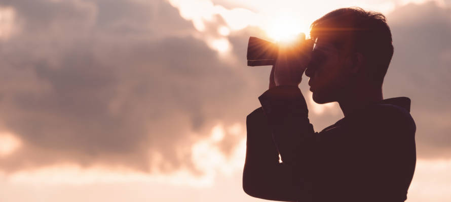 man looking through binoculars