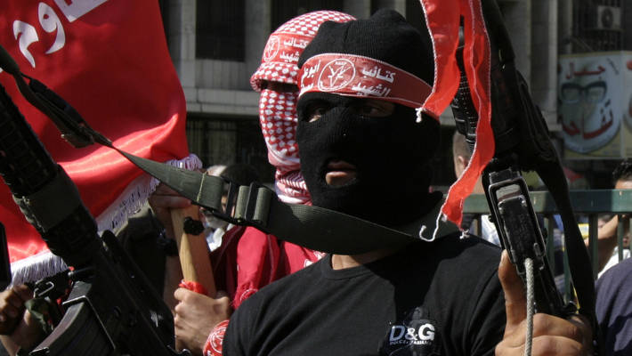 Palestinian gunmen shoot into the air at commemoration ceremony.