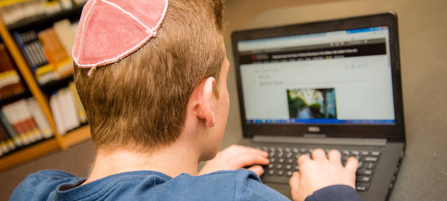 student with kippa on computer
