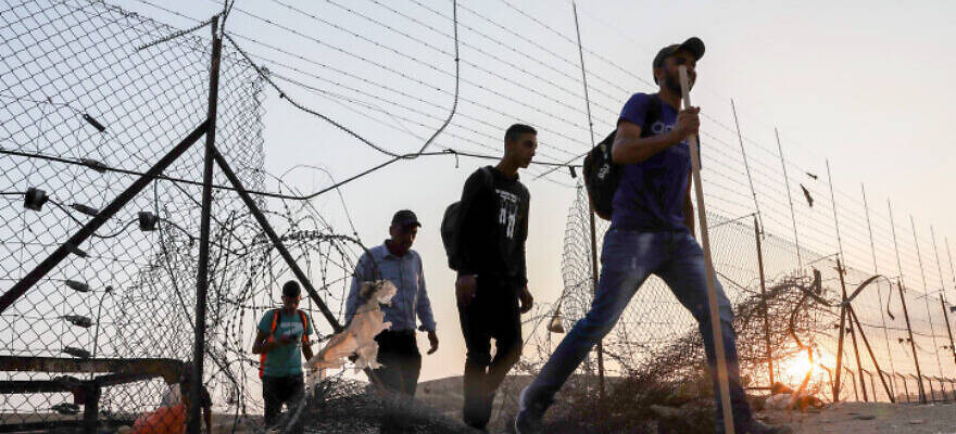 Palestinian Arabs cross border fence