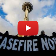 Demonstrators hold up a "Murray: Ceasefire Now!" banner