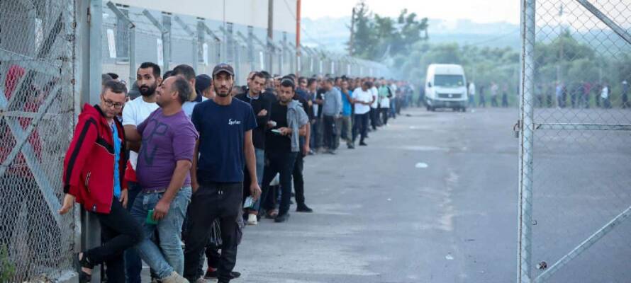 Workers from Gaza stand in line to enter Israel